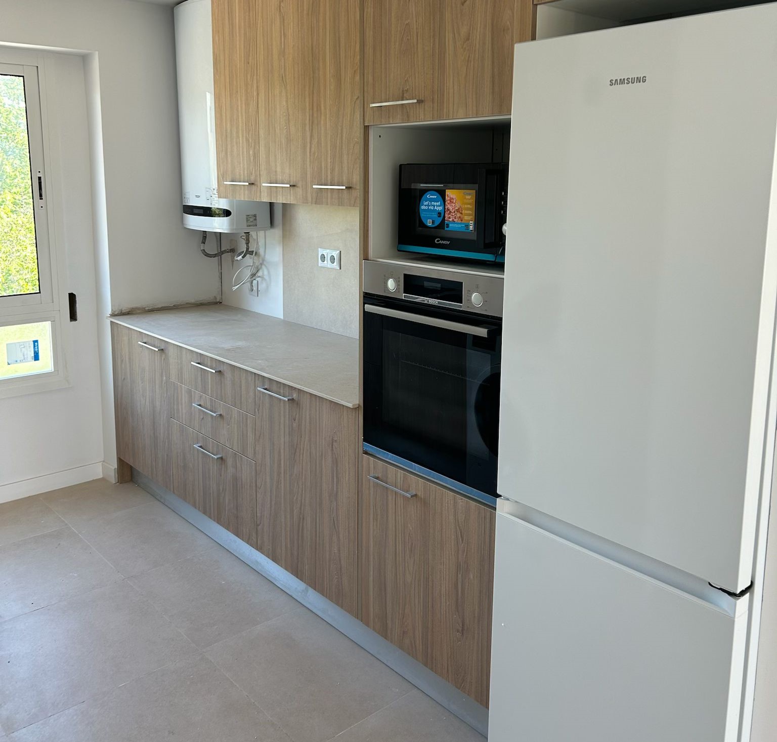 Reforma de cocina moderna y funcional en Tarragona. Diseño de isla central, electrodomésticos integrados y armarios sin tiradores